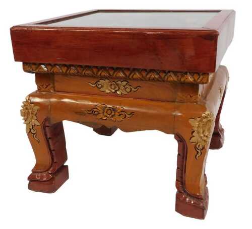 An Eastern carved hardwood coffee table, the glazed top enclosing a panel decorated with elephants and flowers, on out splayed legs, 43cm high, the top 50cm x 50cm.