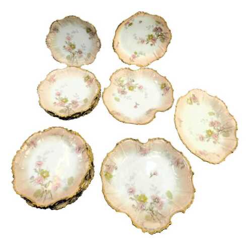 A late 19th/early 20thC Limoges blush porcelain part dessert service, including serving dishes, and plates, each decorated with flowers with a gilt border, printed marks.