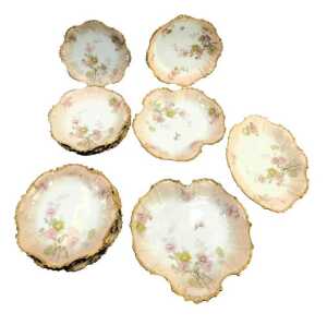 A late 19th/early 20thC Limoges blush porcelain part dessert service, including serving dishes, and plates, each decorated with flowers with a gilt border, printed marks.