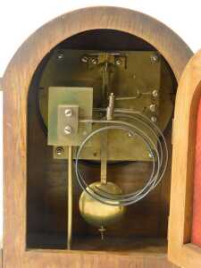 An early 20thC oak cased mantel clock, the silvered circular dial bearing Arabic numerals, eight day, the case of arched form, the moulded base on compressed brass feet, 29cm high. - 3