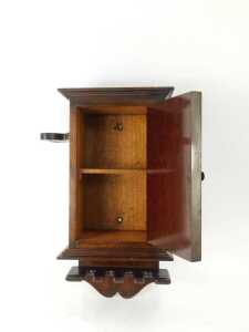 An early 20thC and later oak wall hanging pipe box, the top with an outswept pediment above a bow, fruit and floral carved door enclosing a single shelf, the body flanked by two shaped recesses for pipes, the base with four sections to hold pipes, 42cm hi - 2