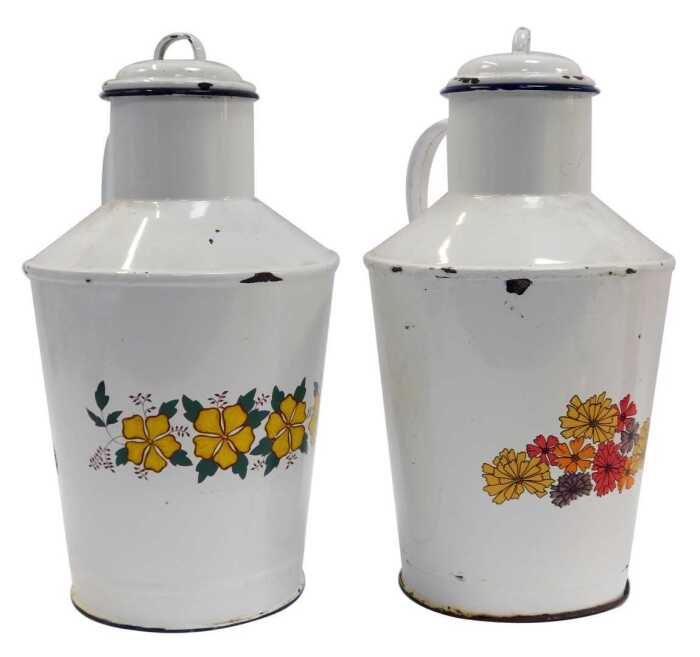 A pair of French enamel milk jugs, each with a lid and decorated to the front with transfer printed flowers, 40cm high.