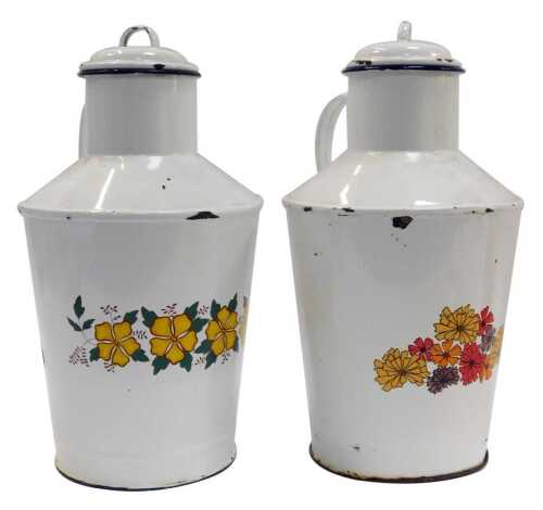 A pair of French enamel milk jugs, each with a lid and decorated to the front with transfer printed flowers, 40cm high.