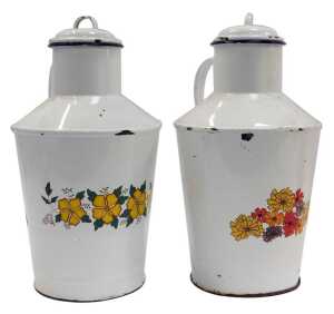 A pair of French enamel milk jugs, each with a lid and decorated to the front with transfer printed flowers, 40cm high.