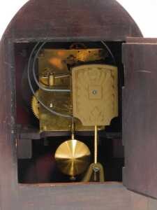 An early 20thC mahogany cased mantel clock, the silvered dial bearing Arabic numerals, Junghans eight day movement with coil strike, the case of domed form, on a moulded base raised on four feet, 30cm high. - 3