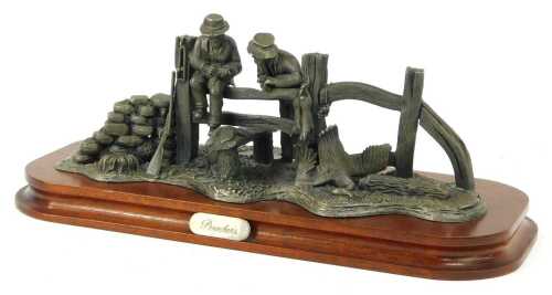 A 20thC pewter figure group titled Poachers, on an oval oak base, 30cm wide.