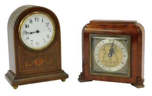 An early 20thC mahogany and inlaid mantel clock, the circular white enamel dial bearing Arabic numerals, eight day movement, the case of domed form inlaid with foliate motif and line inlay, 20cm high. (AF), together with an Elliott mahogany cased mantel c