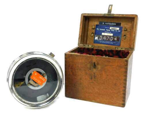 An Automatic Timing Clock Company pigeon clock, in metal casing, 18cm diameter, in an oak case.