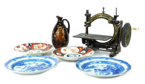 A 19thC cast iron hand operated sewing machine, together with two Imari dishes, two Willow pattern plates, and a Royal Doulton George the Guard jug, 21cm high, (AF).