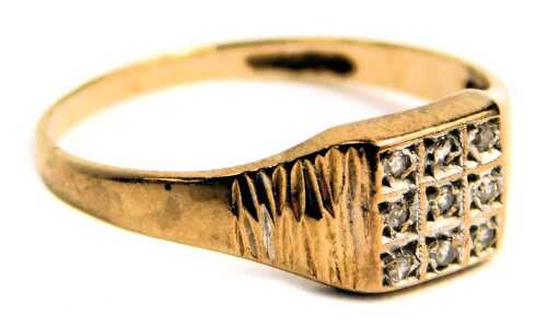 A 9ct gold signet ring, the nine stone set panel set with tiny diamonds, with bark effect shoulders, ring size N, 1.7g all in.