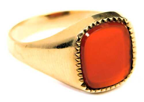 A 9ct gold signet ring, set with rectangular cut orange agate, and a zigzag border, maker FM, London 1971, ring size X&frac12;, 4.8g all in.