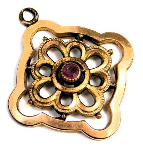 A gold plated Art Nouveau style pendant, the central stone set with a garnet, 2.5cm wide.