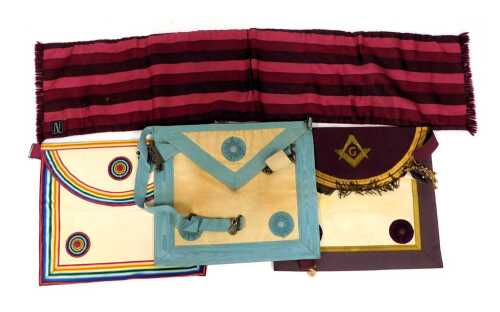 A Masonic regalia apron and sash, with multi coloured rosette.