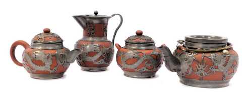 A Chinese redware pottery and metal mounted four piece tea service, comprising teapot, hot water jug, bachelor's teapot and two handled sugar bowl, each piece decorated with dragon and butterfly motifs.