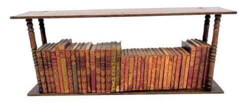 A 20thC oak hanging bookcase, containing various works of fiction, to include Stephenson (RL) Essays of Travel, Harte (Bret) Condensed Novels, various works of Shakespeare, etc., the wall shelf 71cm wide.