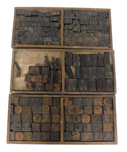 Three printer's drawers, containing vintage wood letterpress numbers, letters, and punctuation, circa150 individual printing blocks, each tray 37cm x 83cm.