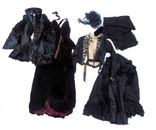 A group of Victorian and later clothing, to include a black satin lace trim and sequin embellishment cape, black lace fabric, a red velvet skirt, etc. (1 box)