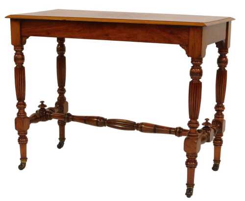 An early 20thC walnut side table, the rectangular top with a moulded edge above four part fluted and turned legs with a turned and fluted H shaped stretcher, on castors, 69cm high, 91cm wide, 43cm deep.