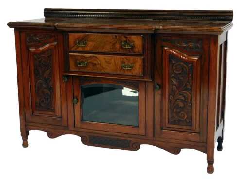 A late Victorian walnut and burr walnut break front sideboard, the top with a raised back with dentil moulding, the base with two drawers above a glass fronted cabinet flanked by two scroll and leaf carved doors, on cylindrical legs, 99cm high, 150cm wide