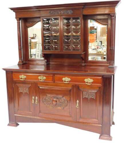 An early 20thC mahogany mirror back dresser, the top with a moulded edge above two glazed doors flanked by two mirrors, with part fluted cylindrical columns, the base with two drawers above two carved cupboards, raised on square carved feet, 197cm high, 1