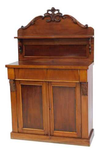 A Victorian mahogany chiffonier, the raised back with a scroll carved top and shelf above a shelf, the base with two cupboard doors enclosing a shelf, on a plinth base, 143cm high, 89cm wide, 38cm deep.