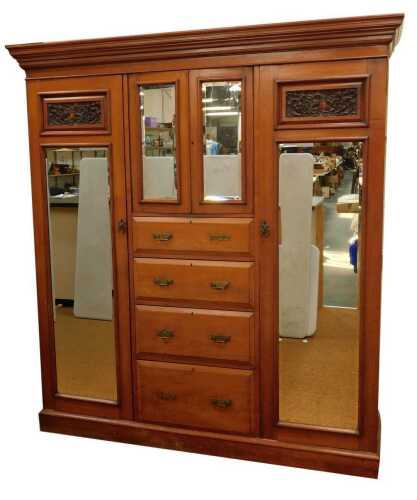 A late 19thC/early 20thC walnut compactum, the top with a moulded edge above two glazed cupboard doors, above five drawers, flanked to either side by two wardrobes inset with mirrored panels, below a carved dragon panel, on a plinth, 211cm high, 187cm wid