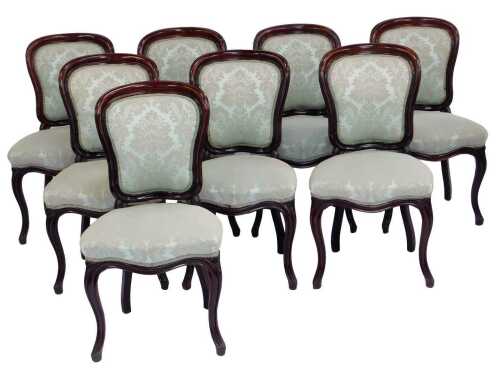 Eight Victorian mahogany dining chairs, each with spoon back, overstuffed upholstered seat and back, on fluted cabriole legs.