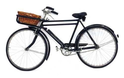 An early 20thC baker's bicycle, in black trim, with wicker basket to front, with later seat and hand grips.
