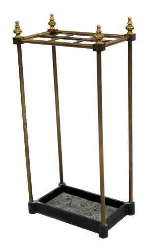 A 20thC brass umbrella stand, each corner with urn type finials, with six recesses for umbrellas/sticks, on cast iron base, 64cm high, 31cm wide, 20cm deep.
