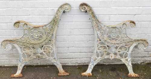 A pair of cast iron bench ends, each floral and white painted, 80cm high.