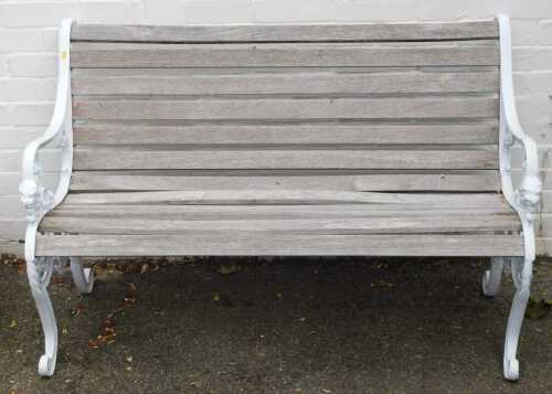 A cast iron and wood painted garden bench, with white painted lion mask bench ends, 82cm high, the bench 126cm wide, 46cm deep.
