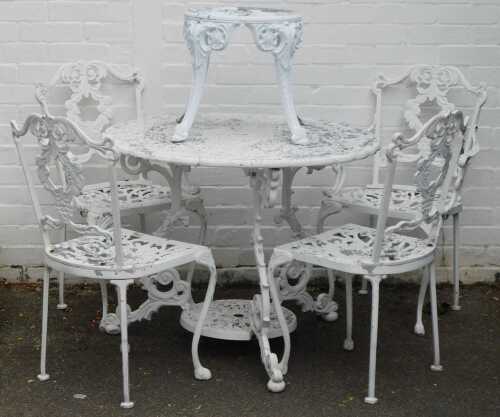 A cast metal circular garden table, with pierced design, painted in white, four grape vine chairs and matching side table, 72cm high, 82cm wide.