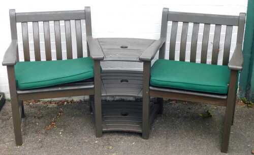 A wooden two seater chair and table set, joined and curved, with green cushions, 92cm high, 150cm wide, 52cm deep.