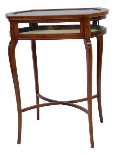 An Edwardian mahogany and marquetry bijouterie table, the glazed hinged top decorated with scrolling and leaf motifs, enclosing a vacant interior, raised on cabriole legs united by an X shaped stretcher, with key, 76cm high, 61cm wide, 42cm deep.