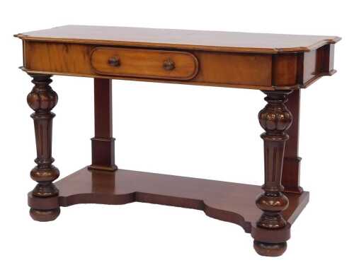 A Victorian mahogany side table, the shaped top above a frieze drawer, raised on turned and fluted columns, with a shaped under tier, raised on compressed bun feet, 74cm high, 122cm wide, 55cm deep.