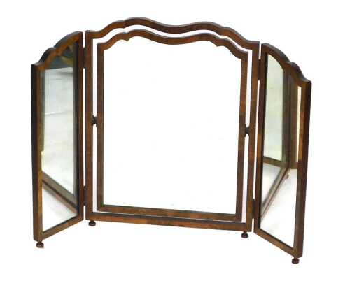 An early 20thC walnut trifold mirror, of shaped form, the central mirror on swing support, on compressed bun feet, 63cm high, approx 80cm wide.