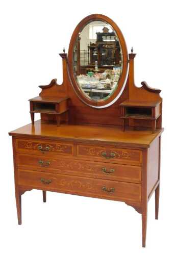 An Edwardian walnut and marquetry mirror back dressing table, the oval swivel mirror flanked by scrolling supports with brass urn finials, the top with two raised drawers, on square tapering supports, the base with two short and two long drawers, on squar
