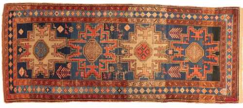 A Kazak rug, blue ground, with multiple medallion decoration, within three narrow borders, 108cm x 264cm. (AF)