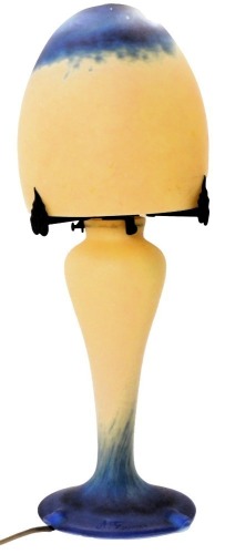 A French Art Deco style mushroom lamp, in mottled dark blue and cream colourway, the mushroom shaped shade resting on three metal leaf supports, on a cylindrical tapering stem, on circular base marked A France, 47cm high.