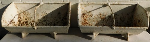 Two cast and white painted two-sectional feeding troughs, 33cm high, 62cm wide, 30cm deep.