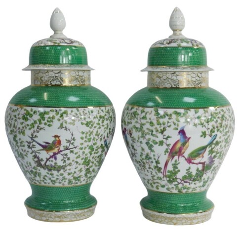A pair of 19thC German porcelain jars and covers, each with a bird and leaf decorated central panel, with a green scale border, 47cm high.