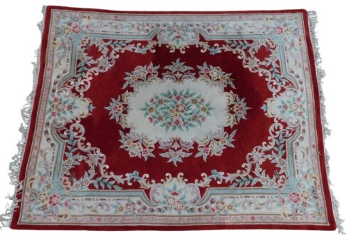A Chinese wool cut rug, red ground with floral central medallion within one wide and two narrow borders, 300cm x 238cm.