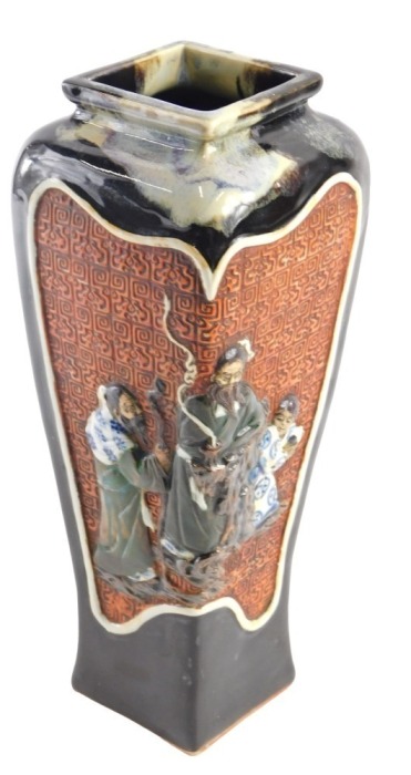 A Japanese stoneware vase, of tapered square section form, with panels of raised decoration, including figural characters, and landscape with a pagoda and Mount Fuji, within brown and grey running glazes, impressed signature to the base, 30.5cm high.