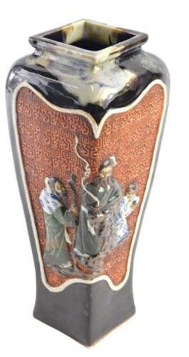 A Japanese stoneware vase, of tapered square section form, with panels of raised decoration, including figural characters, and landscape with a pagoda and Mount Fuji, within brown and grey running glazes, impressed signature to the base, 30.5cm high.