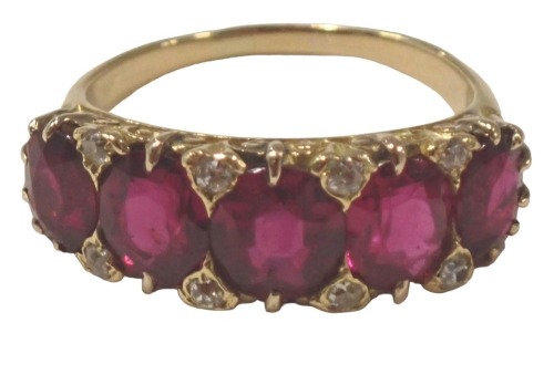 A ruby and diamond half hoop dress ring, the oval rubies in claw setting, with eight tiny diamonds to border, on scroll shoulders, yellow metal unmarked, ring size P, 5.9g all in, boxed.