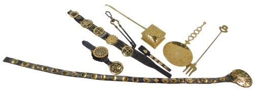 A collection of horse brasses with Martingale straps and other brass, including square chestnut roaster, brass skimmer, toasting fork, etc.