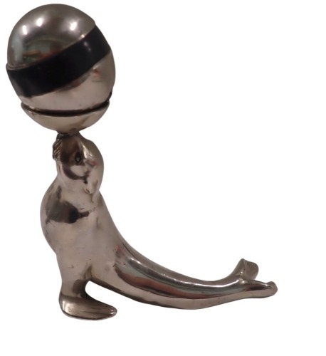 A 1950s/60s chrome ash tray table lighter, formed as a seal holding ball, 16cm high, 14cm wide.