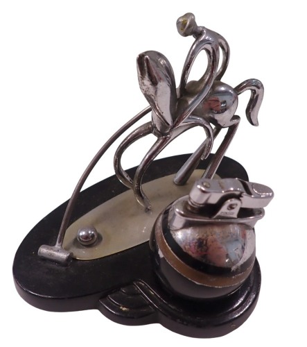 An Art Deco Ronson table lighter, stylised and formed as a polo player, in chrome, on blackened base, with orb lighter, 11cm high, 13cm wide, 10cm deep.