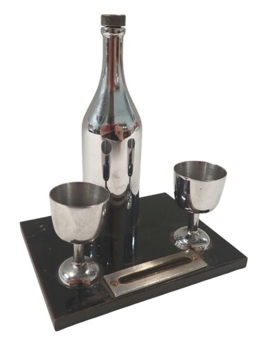 A 1940s/50s table lighter, formed as a bottle of wine and two goblets, central strike, 13cm high, 10cm wide, 7cm deep.