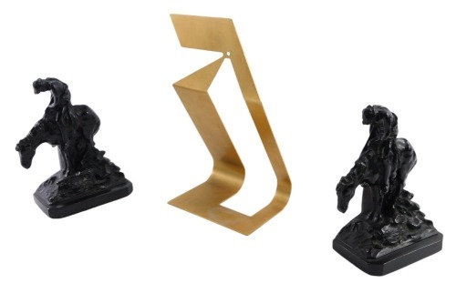 A pair of Ronson cast book ends, each depicting figure riding horse, 17cm high, and a gold coloured brush finish display stand. (3)
